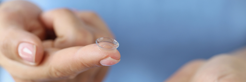A woman holding a contact lens