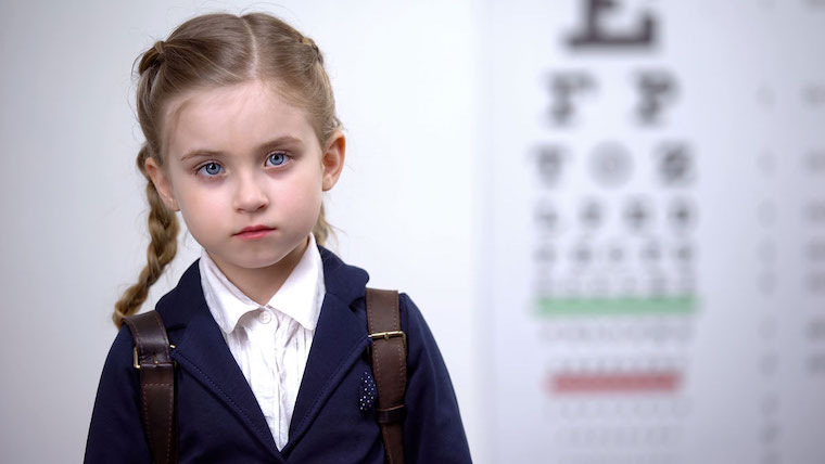 girl with blurry vision test in background